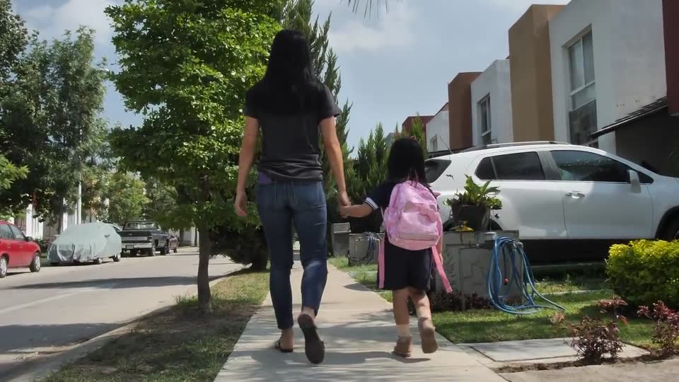 A mother and daughter walking together outdoors